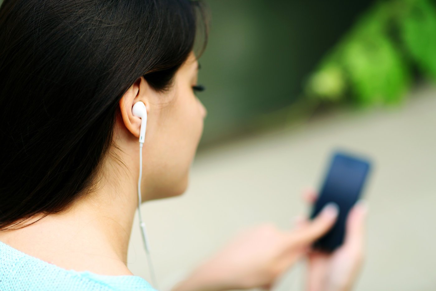 Stock photo closeup portrait of a woman in headphones listening to music with her smartphone 212128963
